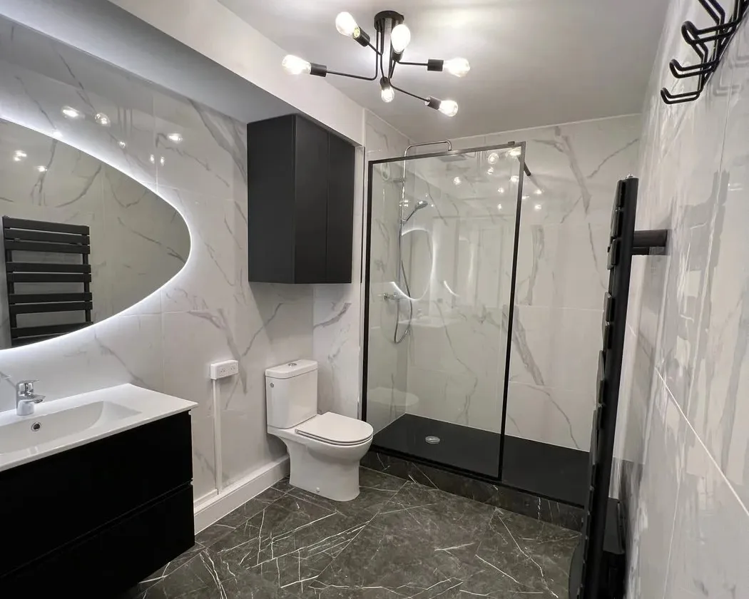 Salle de bain terminée par Balagna Rénovation près de Montpellier : sol en marbre noir, murs marbrés, douche à l'italienne et miroir LED