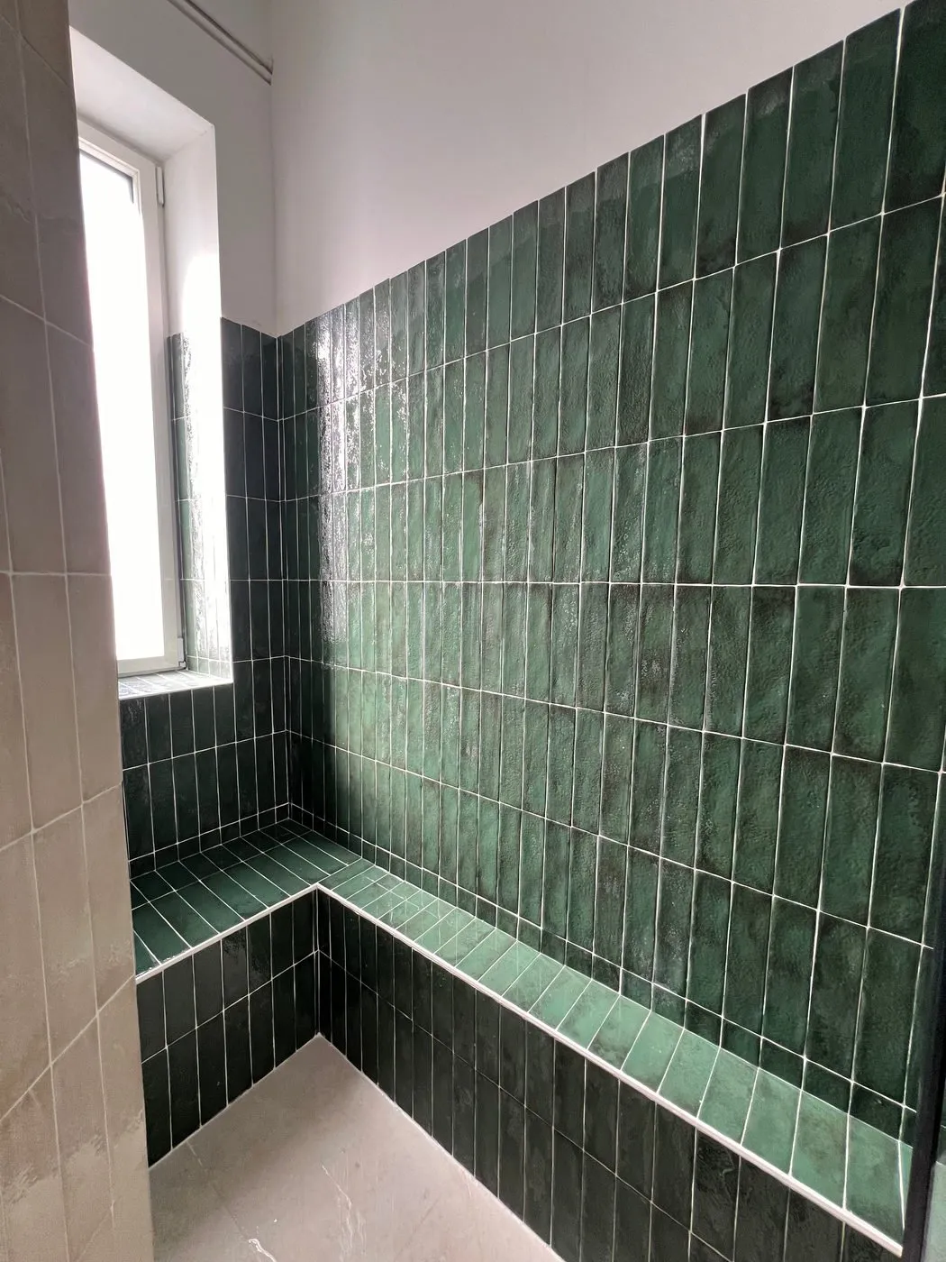 Douche avec receveur extra-plat blanc et murs en zellige vert, sans marche